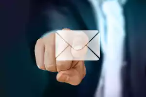 Montage: Eine Person im Anzug zeigt mit dem rechten Zeigefinger auf ein E-Mail-Symbol