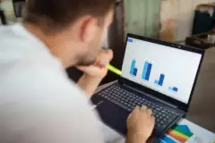 Person blickt auf Laptop mit Diagramm