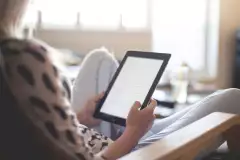 Person liest auf einem Tablet.