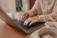Nahaufnahme einer Person die an einem Laptop arbeitet
