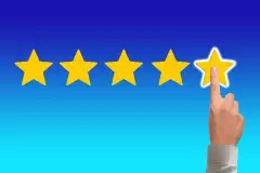 5 Sterne, eine Hand zeigt auf den 5. Stern