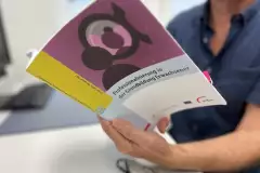 Person hält das Buch "Professionalisierung in der Grundbildung Erwachsener"