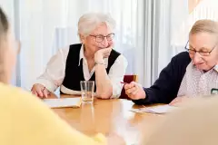 zwei ältere Menschen schreiben auf Papier