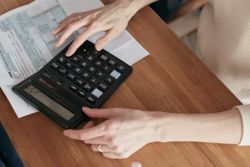 Weibliche Person arbeitet am Taschenrechner