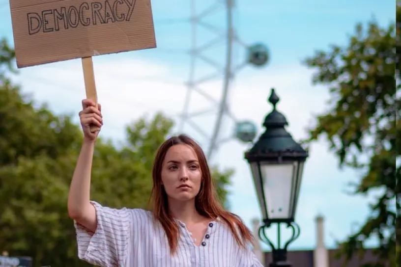 Person mit Democracy Schild