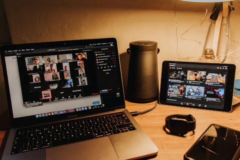 Schreibtisch mit Notebook und Tablet in gedimmtem Licht