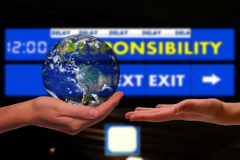 Erde wird weitergegeben. Im Hintergrund steht „Responsibility next exit“