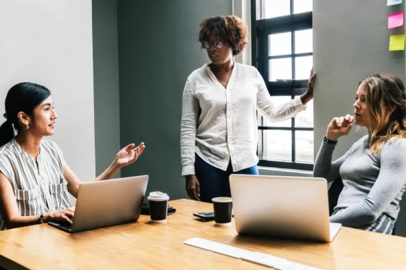 Drei Frauen mit Laptops und Whiteboard