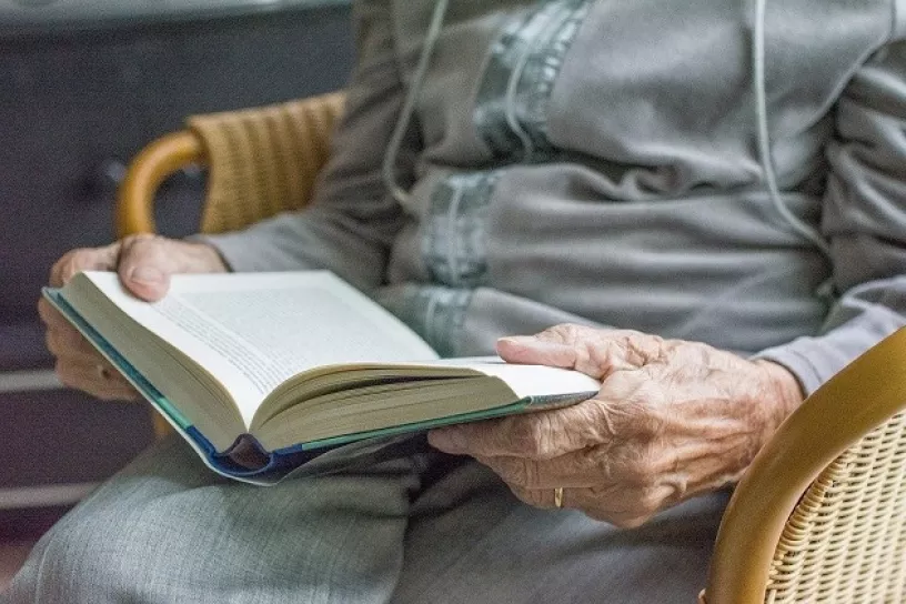 Ältere Person liest in Buch