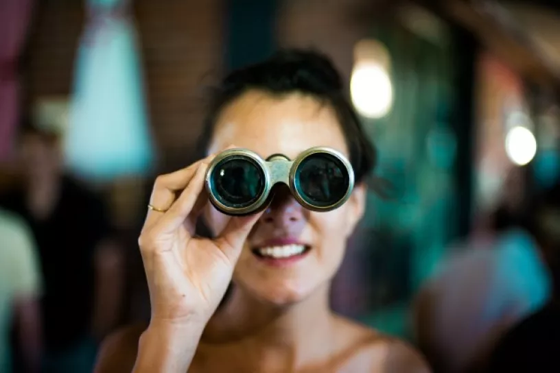 Frau schaut durch Fernglas