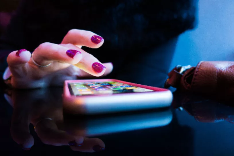 Eine Person tippt auf den Touchscreen eines Smartphones.