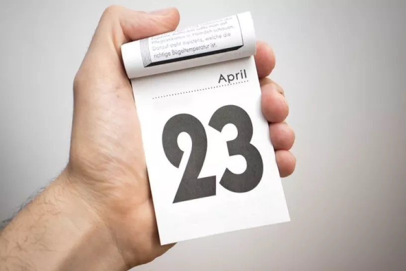 Hand hält Abreißkalender, darauf steht 23. April. 