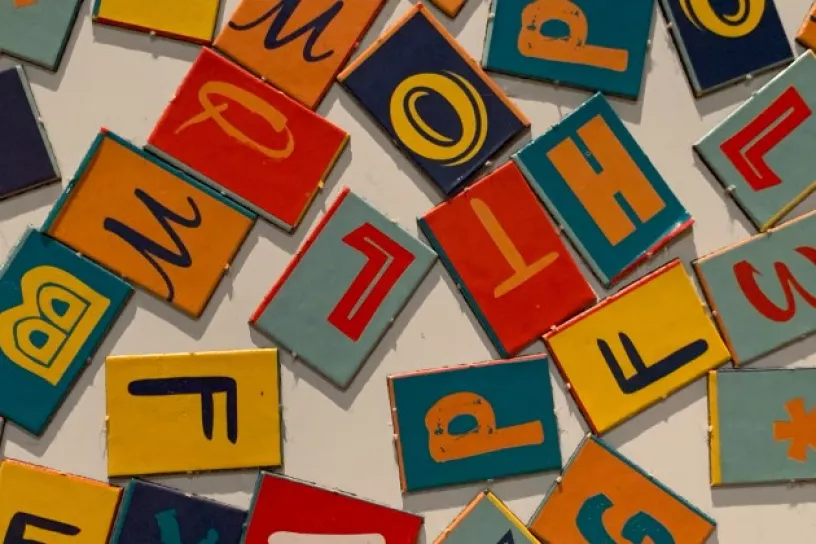Einzelne durcheinandergewürfelte Buchstaben auf kleinen Pappkarten