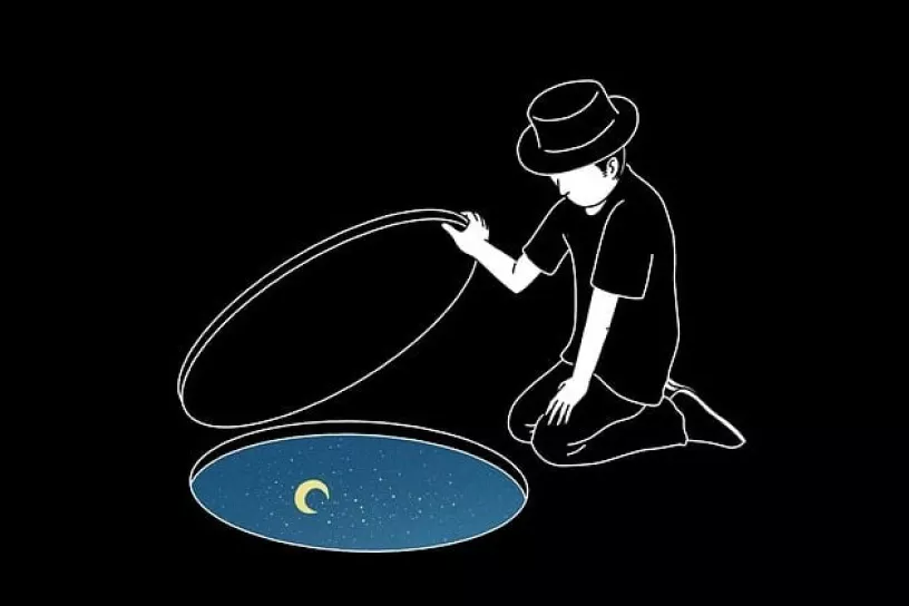 Person mit Hut kniet vor einer Öffnung am Boden, in der sich ein Sternenhimmel und Mond befinden