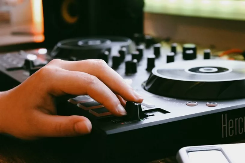 Hand liegt auf einem Audiomixer