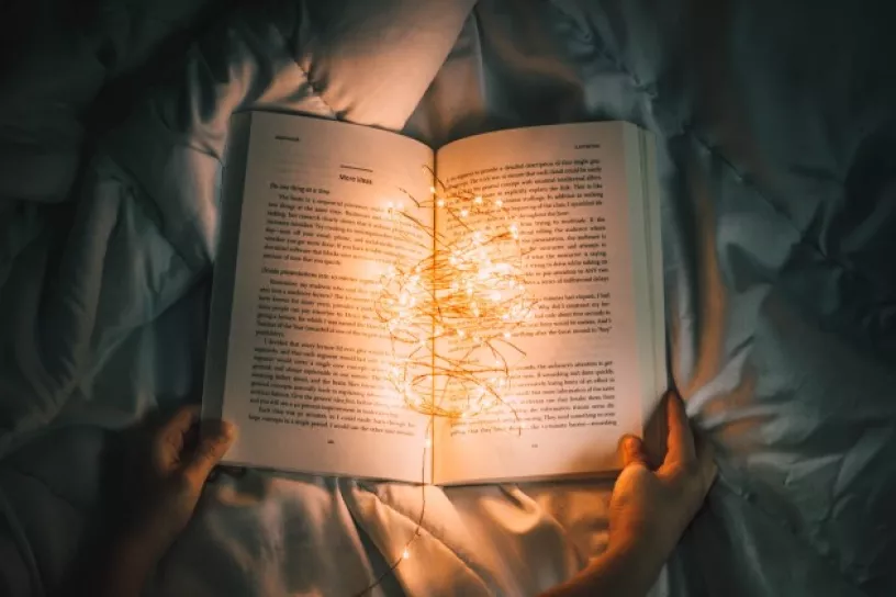 Offenes Buch, darin eine kleine leuchtende Lichterkette
