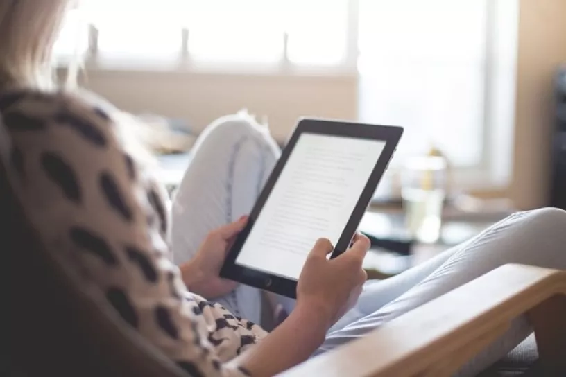 Person liest auf E-Reader.