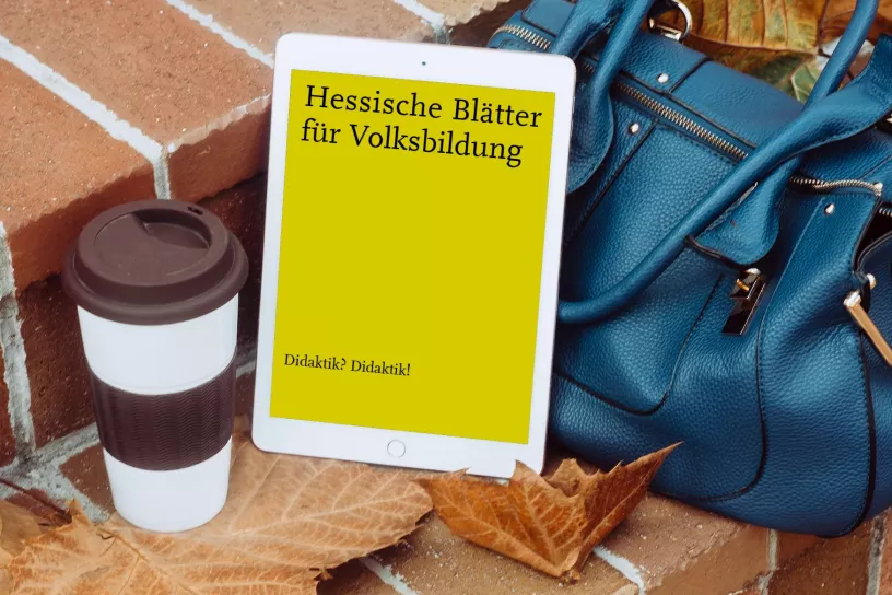 Kaffebecher,Tasche, verwelktes Blatt, ein Tablet - darauf ein Ausschnitt des HBV-Covers
