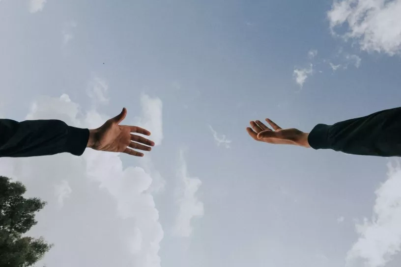 Recht und links je eine Hand, die einander zugewandt sind