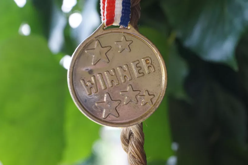 Medaille, darauf steht „WINNER“.