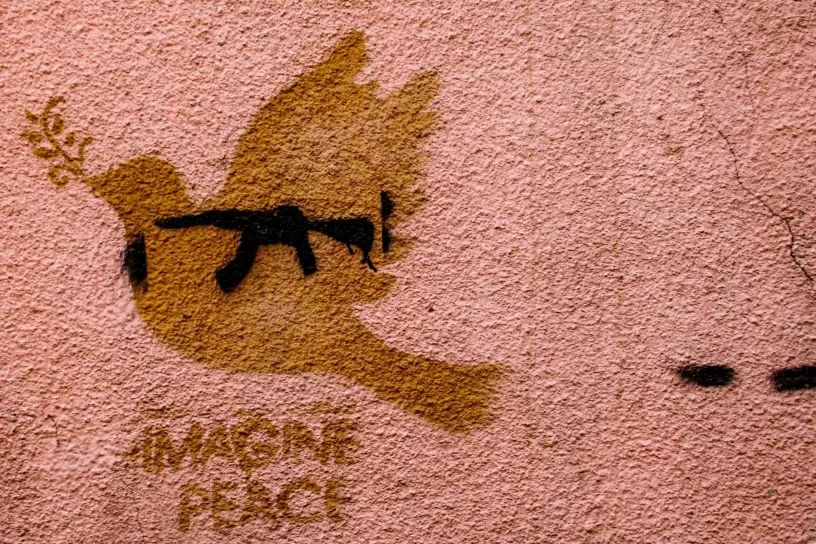 Graffiti einer Taube mit Waffe