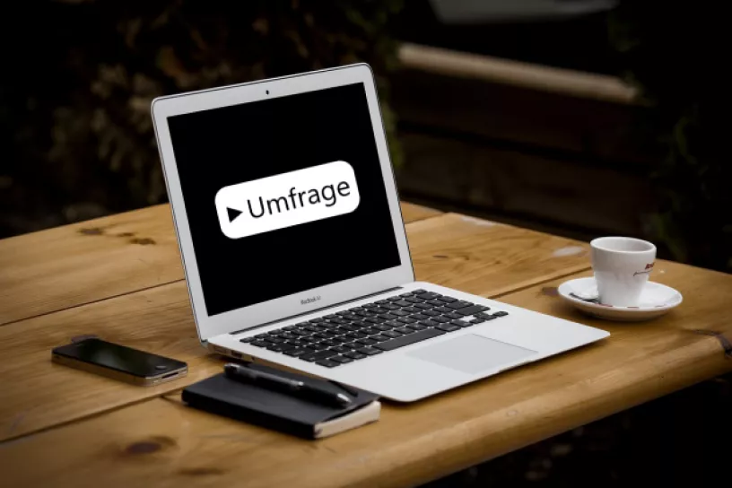 Laptop auf einem Tisch. Auf dem Bildschirm steht "Umfrage".